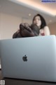 A woman sitting on top of a laptop computer.