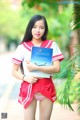 A woman in a red and white uniform holding a book.