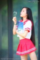 A woman in a red and white uniform holding a book.