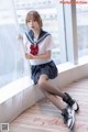 A woman in a sailor outfit sitting on a window sill.