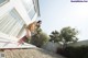 A woman standing on a skateboard in front of a house.