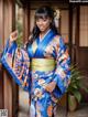 A woman in a blue and orange kimono posing for a picture.