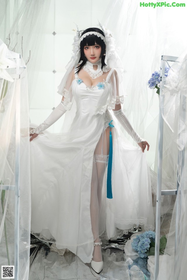 A woman in a white wedding dress posing for a picture.