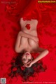 A woman laying on a bed of red rose petals.