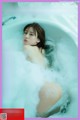 A woman in a bathtub with foam on her body.