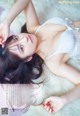 A woman laying on top of a white rug.