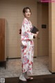 A woman in a kimono holding a book in her hands.