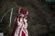 A woman in a red and white dress holding a sword.