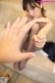 A woman sitting on a couch with her hands outstretched.