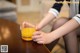 A woman sitting at a table holding a glass of orange juice.