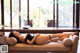 A woman laying on a couch in a living room.