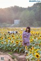 A woman standing in a field of sunflowers.