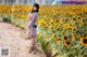 A woman standing in a field of sunflowers.