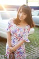 A woman in a floral dress posing for a picture.