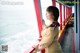 A woman standing on the deck of a boat looking out at the ocean.