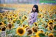 A woman standing in a field of sunflowers.