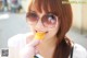 A woman wearing sunglasses eating a piece of food.