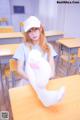 A girl sitting at a desk with a stuffed animal.