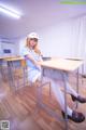 A woman sitting at a desk in a classroom.