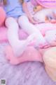 A girl laying on top of a bed next to a stuffed animal.