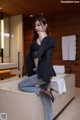 A woman sitting on top of a bathtub in a bathroom.