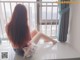 A woman sitting on a window sill looking out a window.