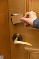 A person opening a door with a card in their hand.